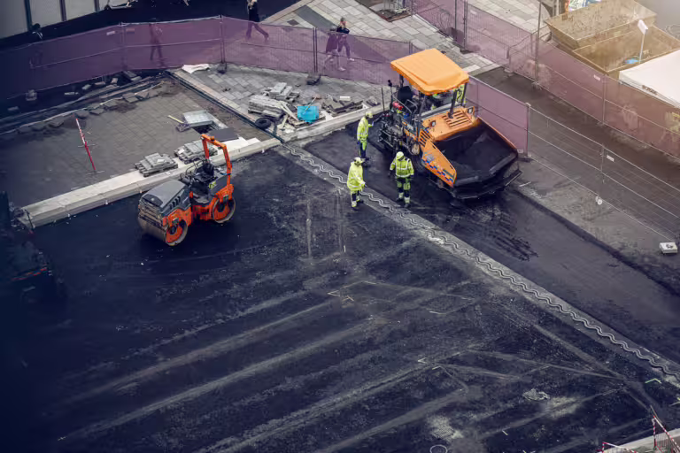 Dronebilde av byggmaskiner på en byggeplass.