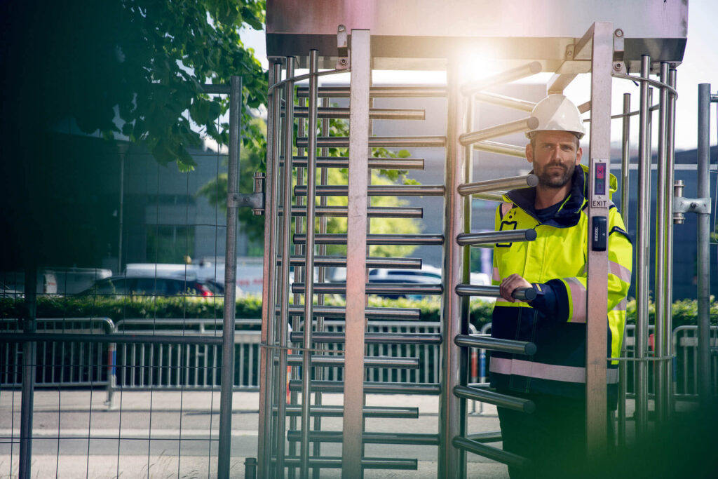 Arbeider går gjennom digital adgangsgrind på byggeplass.