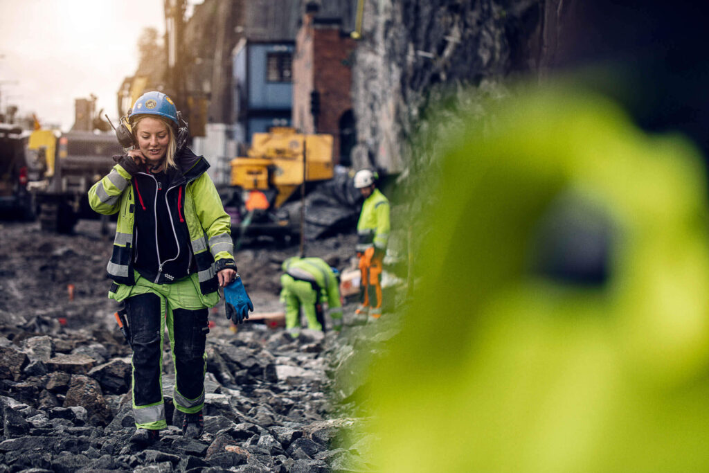 Arbeidere på byggeplass bruker digital løsning for utleie og lagerstyring.