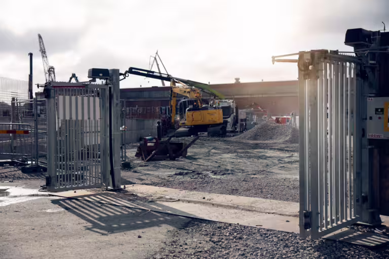 Kjøretøy passerer gjennom kjøreport ved byggeplass med digital adgangskontroll.