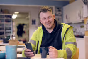 man med Ease CheckIn app i byggbod.