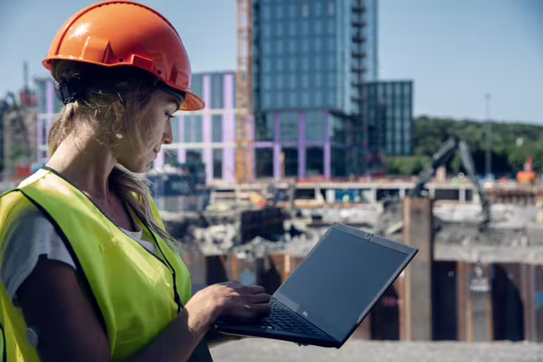 kvinna med laptop på byggarbetsplats