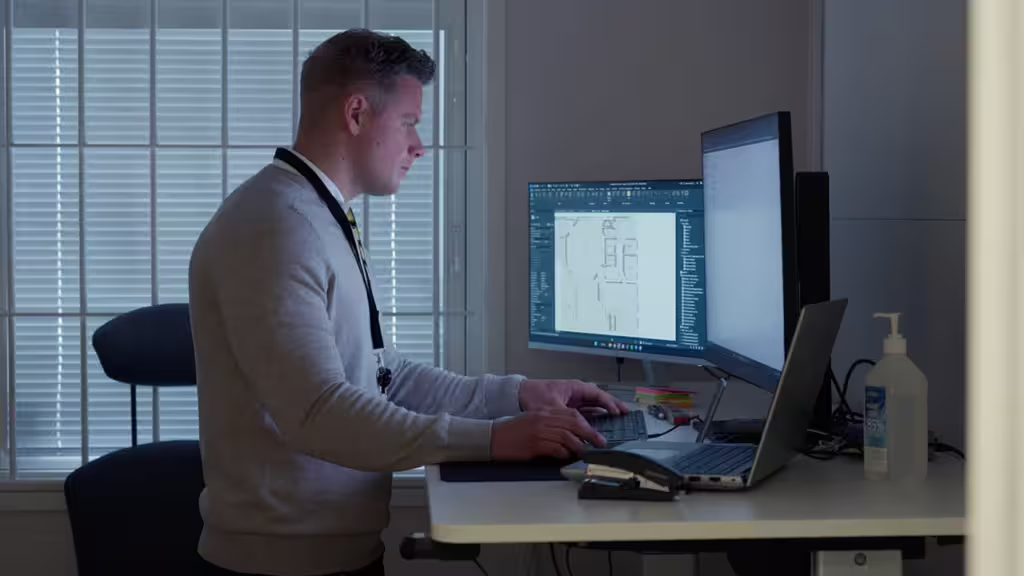 Man vid dator som ser över access på byggarbetsplats