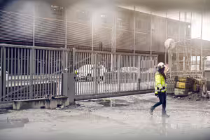 kvinna vid fordonsgrindar på byggarbetsplats