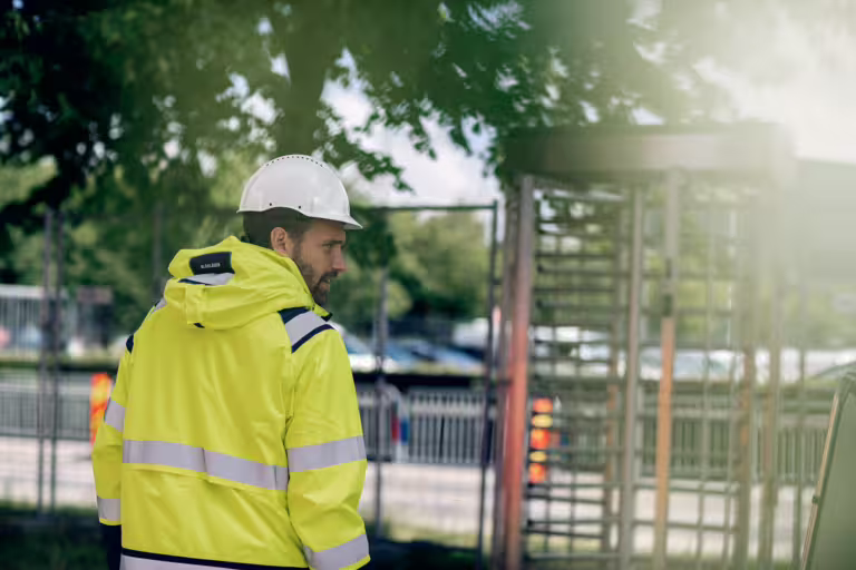 Man på väg mot en rotationsgrind på byggarbetsplats.