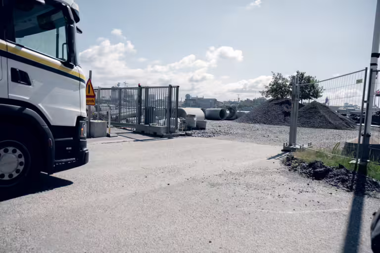 lastbil kör igenom fordonsgrind med grindstyrning till byggarbetsplats.
