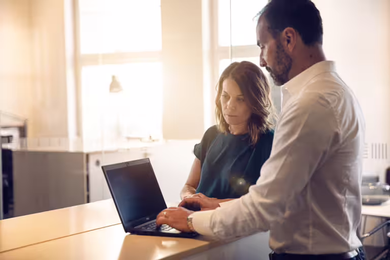 personer på kontor som tittar på en datorskärm.