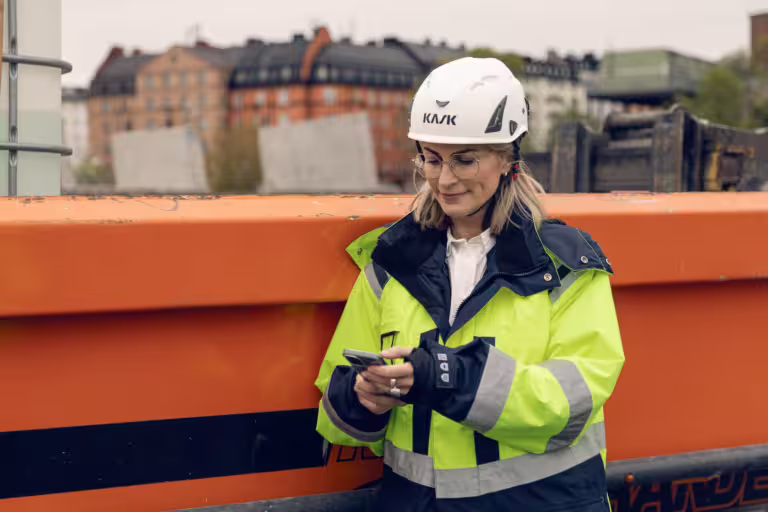 Woman holding a phone on a construction site