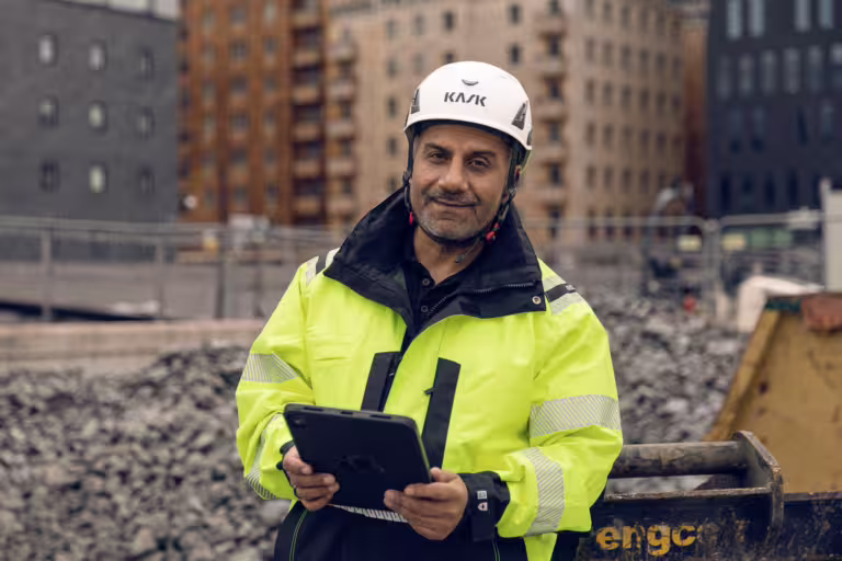 byggarbetare med surfplatta för digitala KMA-processer på byggarbetsplats