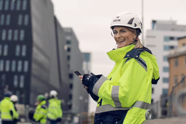 leende byggarbetare med varselkläder och vit hjälm