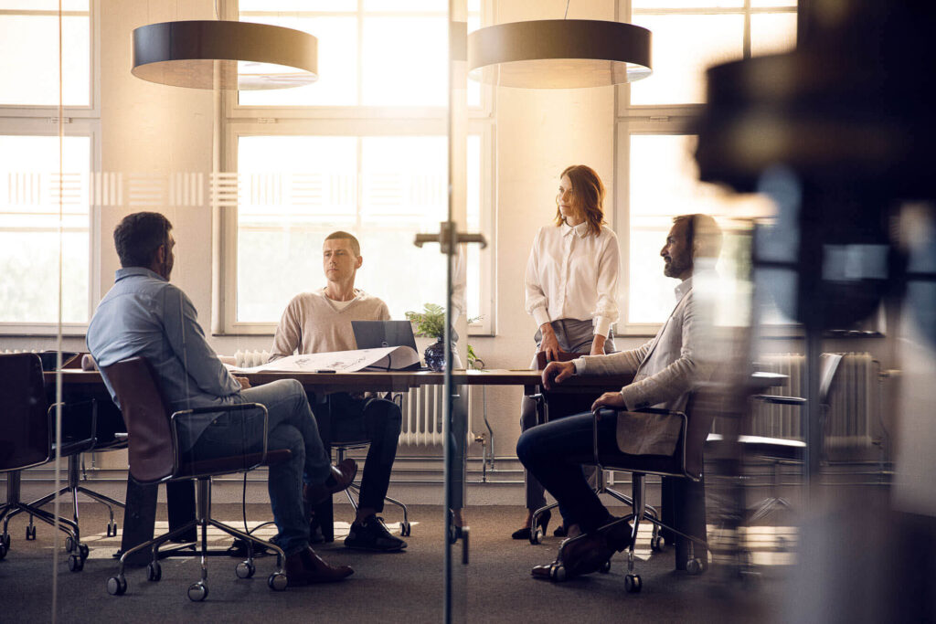 Miljöbild på kontor med människor i mötesrum