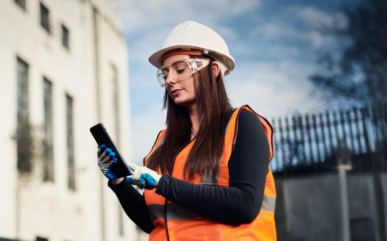 Woman holding a phone on construction site