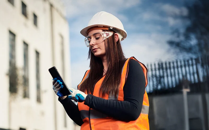 Woman holding a phone on construction site