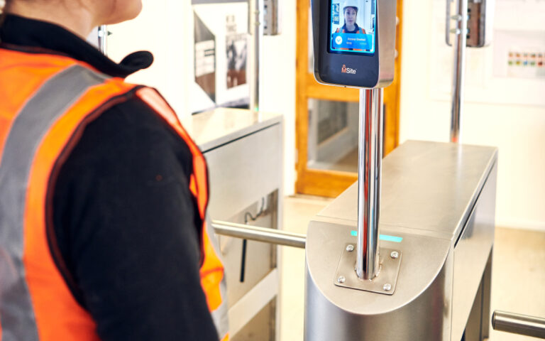 construction worker signing in with msite face mini and walking through a half height turnstile