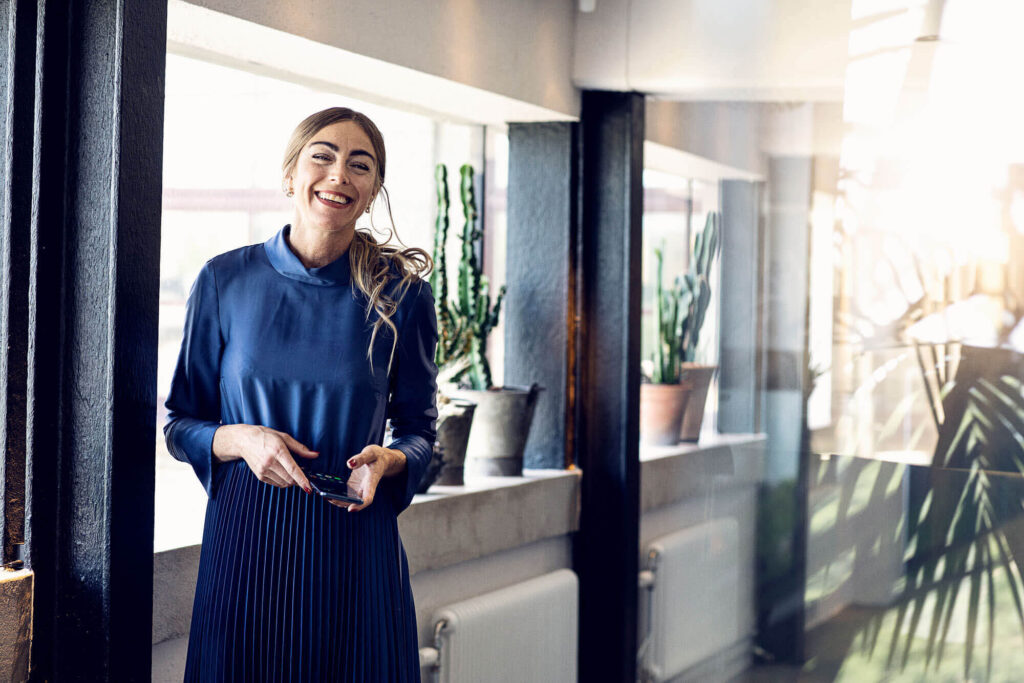 women in an office with mobile phone in hand