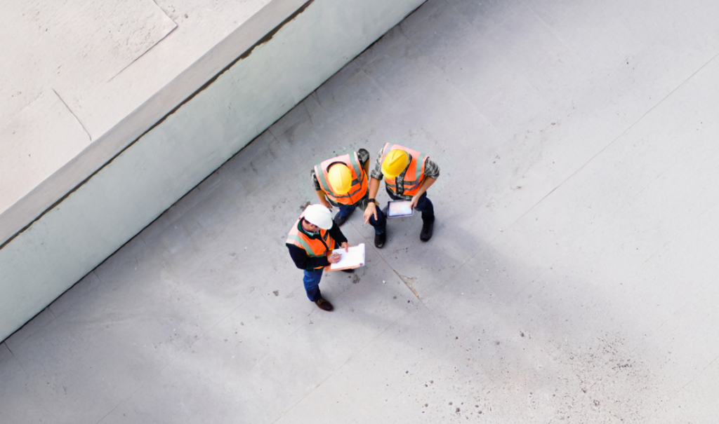 Construction workers on site looking at Ipad and list to manage a project