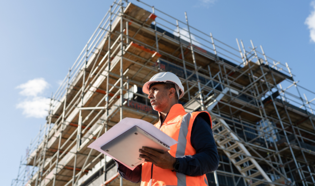 construction worker onsite with his laptop